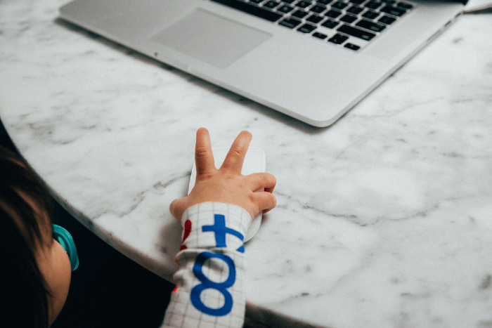 This is an image of a childs hand using a mouse with computer